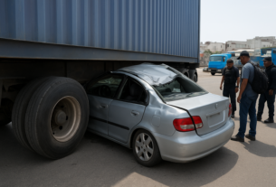 Carro fica preso debaixo de carreta com contêiner após colisão em Cariacica